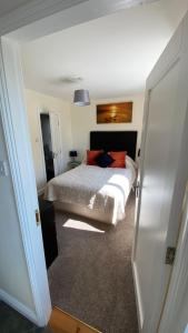 1 dormitorio con 1 cama con edredón blanco en Hill Sea View Cottage, en Glengarriff