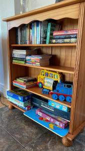 ein Bücherregal mit einem Spielzeugzug und Büchern in der Unterkunft Hill Sea View Cottage in Glengarriff