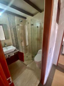 ein Bad mit einer Dusche, einem WC und einem Waschbecken in der Unterkunft Hospedaje Iraca - Pueblito Boyacense in Duitama