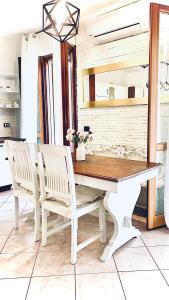 a dining room table with two white chairs around it at Eleonora Home in Porto Torres