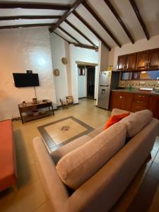 ein Wohnzimmer mit einem Sofa und einer Küche in der Unterkunft Hospedaje Iraca - Pueblito Boyacense in Duitama