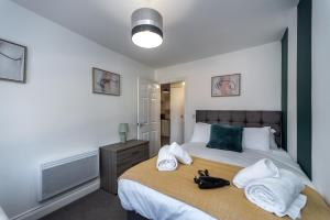 a bedroom with a large bed with towels on it at Croft Road Apartments in Neath