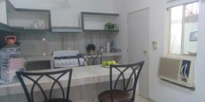 une cuisine avec deux chaises et un comptoir avec un comptoir dans l'établissement Apartamentos Playa Sur 184, à Mazatlán