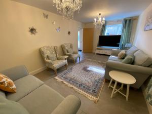 a living room with a couch and chairs and a tv at Burton - 4 Bedroom Detached Home in Shenley Church End