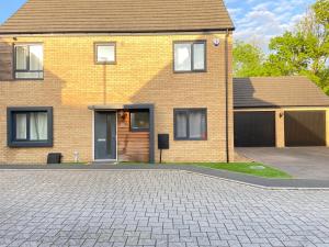 a brick house with a driveway in front of it at Burton - 4 Bedroom Detached Home in Shenley Church End