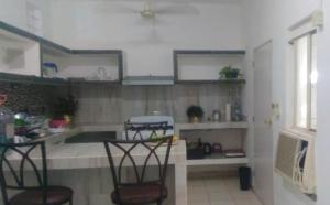 - une cuisine avec 2 chaises et une table dans l'établissement Apartamentos Playa Sur 184, à Mazatlán
