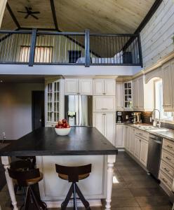 a kitchen with a island with a bowl of fruit on it at Chalet aux mille étoiles near Mt-Tremblant with Hot Tub in La Conception