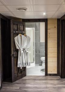 a bathroom with a toilet and a door with a towel at Chalet aux mille étoiles near Mt-Tremblant with Hot Tub in La Conception +44 photos