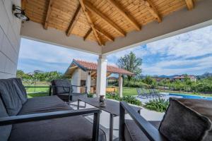 an outdoor patio with chairs and a pergola at Villa Modriola heated Pool in Donji Proložac
