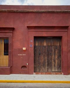 瓦哈卡德華雷斯的住宿－Hotel Escondido Oaxaca, a Member of Design Hotels，两扇门在两边的红色建筑