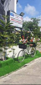 un vélo garé à côté d'un panneau fleuri dans l'établissement Lucena Meg's Studio Apmnt VIP rm-Near SM-Wifi, à Ilayang Dupay