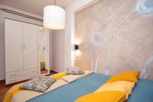 a bedroom with a bed with yellow and gray pillows at Romantic Villa Green Sky with Pool and Garden in Nedeščina +42 photos