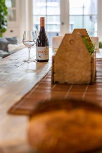 una bottiglia di vino e un bicchiere su un tavolo di legno di The Edward Townhouses 155 & 157 a Orange