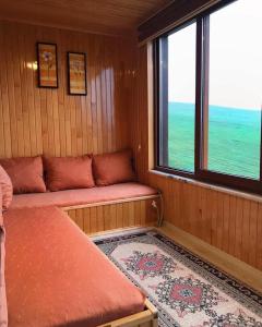 a small room with a bed and two windows at Karester Villa Apart in Uzungöl