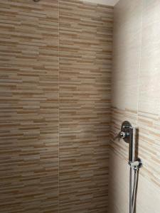 La salle de bains est pourvue d'une douche et d'un mur en bois. dans l'établissement De Nicolò Home, à Putignano