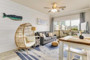 ein Wohnzimmer mit einem Rattanstuhl und einer Couch in der Unterkunft Baywatch F5 in Pensacola Beach