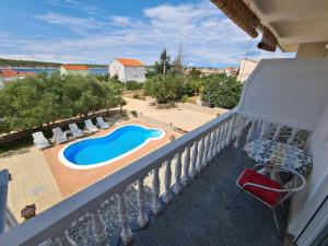 balcón con piscina y patio con sillas en Seaside apartments with a swimming pool Barbat, Rab - 4951, en Rab