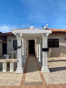 a building with white columns in front of a building at 3-bedroom villa with a jacuzzi in Noord