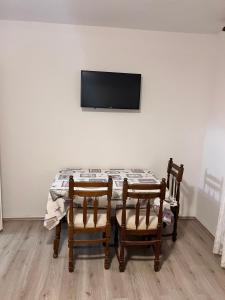 a dining room table with two chairs and a television at Apartments by the sea Metajna, Pag - 6465 in Metajna