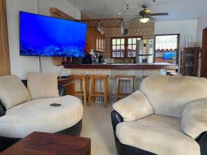 a living room with two couches and a flat screen tv at 3-bedroom villa with a jacuzzi in Noord