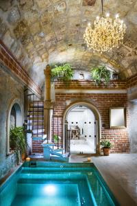 a swimming pool in a building with a chandelier at La Hostería Boutique Hotel in Arequipa