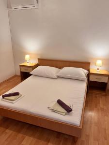 a bedroom with a bed with two towels on it at Apartment Metajna 6465c in Metajna
