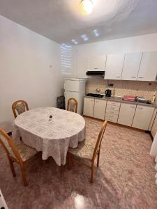 a kitchen with a table and chairs in a room at Apartment Metajna 6465c in Metajna