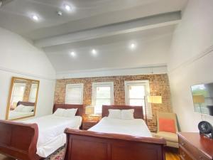 a bedroom with two beds and a brick wall at Good Night Sleep 1Bdrm 2 Queen Beds in Washington, D.C.