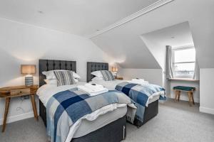 two beds in a room with white and blue at Double Green House, Playfair Terrace in St. Andrews