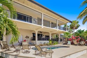 a villa with a swimming pool and chairs at Sombrero Beach Retreat in Marathon