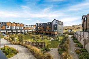 an apartment complex with a courtyard with trees and buildings at Remarkables Retreat Apartment in Queenstown