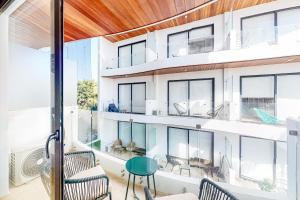a room with large windows and a table and chairs at Menesse Midtown 2 Unit 208 in Playa del Carmen