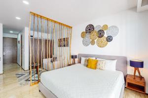a bedroom with a white bed with yellow pillows at Menesse Midtown 2 Unit 208 in Playa del Carmen