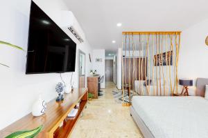 a bedroom with a bed and a tv on a wall at Menesse Midtown 2 Unit 208 in Playa del Carmen
