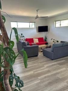 a living room with two couches and a red couch at Serenity in Style in Kalbarri