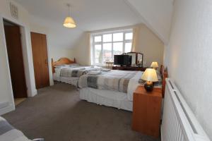 a bedroom with a bed and a desk at West Point Hotel Bed and Breakfast in Colwyn Bay