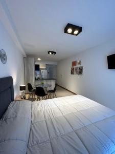 1 dormitorio con 1 cama blanca grande y cocina en ESTUDIO DORREGO en Rosario