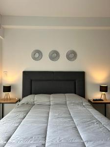 1 dormitorio con 1 cama blanca grande y 2 lámparas en ESTUDIO DORREGO en Rosario