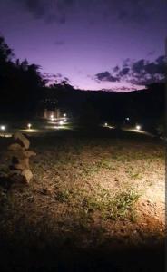 a field at night with lights in the background at Chalé Caminho do Paiol in São Bento do Sapucaí +4 photos