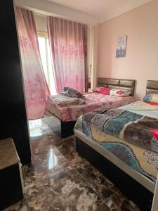 1 dormitorio con 2 camas y ventana en شقه فندقيه مطله على البحر, en Marsa Matruh