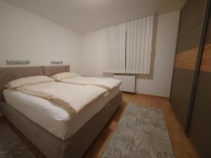 a white bedroom with a bed and a window at Apartments by the sea Duga Luka - Prtlog, Labin - 2367 in Drenje