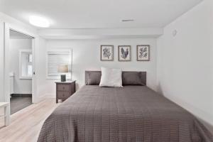 a bedroom with a bed and a night stand with a lamp at Naramata paradise! Huge Pool & Deck, Families Welcome! in Naramata