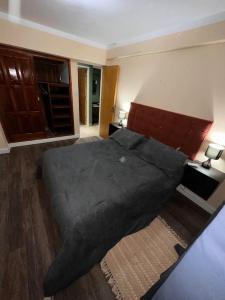 um quarto com uma cama grande e um cobertor preto em Lindo departamento pleno centro. em San Fernando del Valle de Catamarca