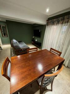 uma sala de estar com uma mesa de madeira e cadeiras em Lindo departamento pleno centro. em San Fernando del Valle de Catamarca