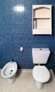 Baño de azulejos azules con aseo y lavamanos en Amplia casa con estacionamiento en Esquel