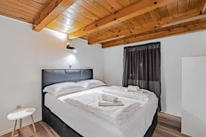 una camera da letto con un grande letto bianco e un soffitto in legno di Seaside house for families with children Postup, Peljesac - 20849 a Orebić (Sabbioncello)