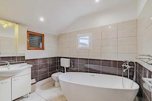 un bagno con vasca, WC e lavandino di Seaside house for families with children Postup, Peljesac - 20849 a Orebić (Sabbioncello)