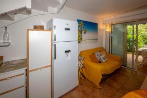 a kitchen with a white refrigerator and a yellow chair at Rêve de Palmier in Le Gosier
