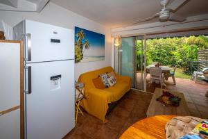 a living room with a yellow couch and a refrigerator at Rêve de Palmier in Le Gosier