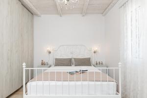 ナクソス・コラにあるVilla Nektar, Luxury Apartment in Chora Naxosの白いヘッドボード付きのベッドが備わる白いベッドルーム1室